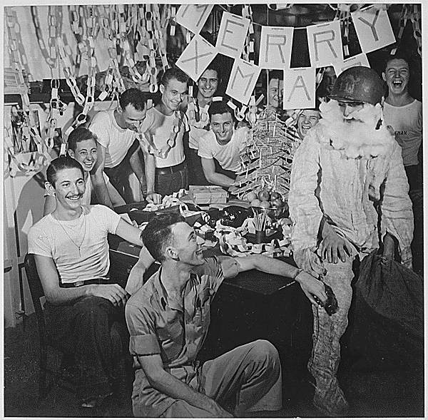 Personnel of USS Lexington celebrate Christmas with decorations and a helmeted Santa Claus