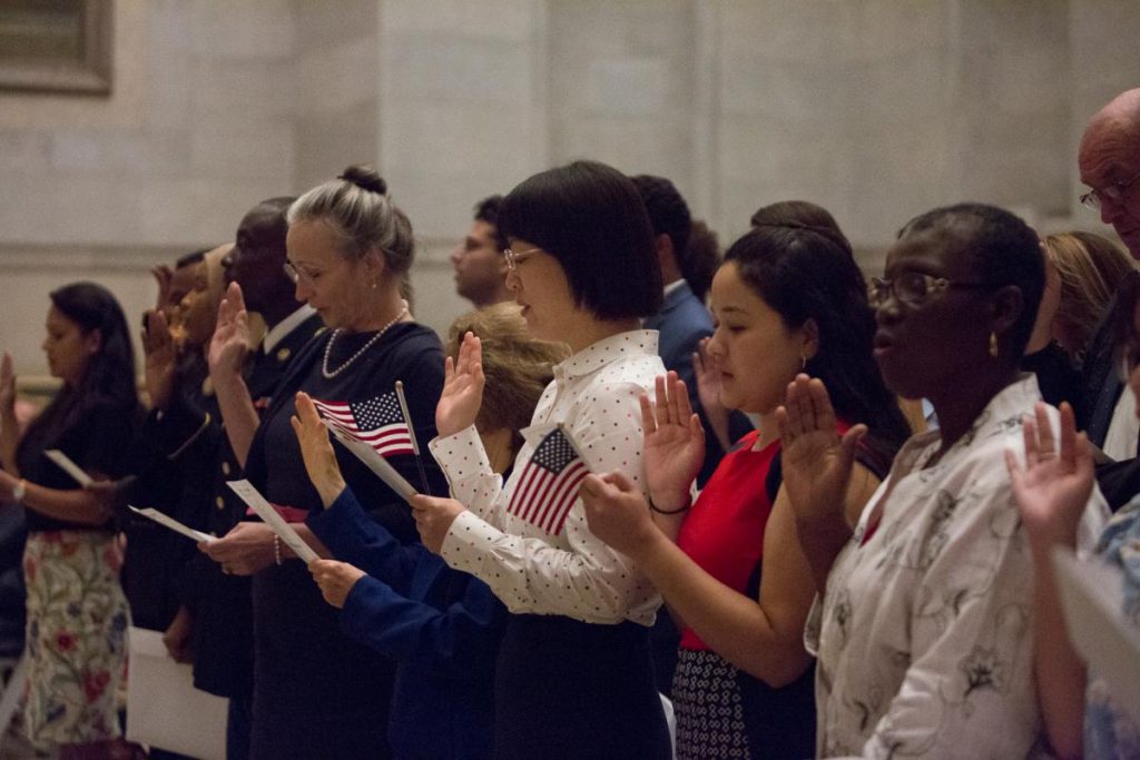 Image of naturalized U.S. citizens taking the oath of allegiance at the Naturalization Ceremony