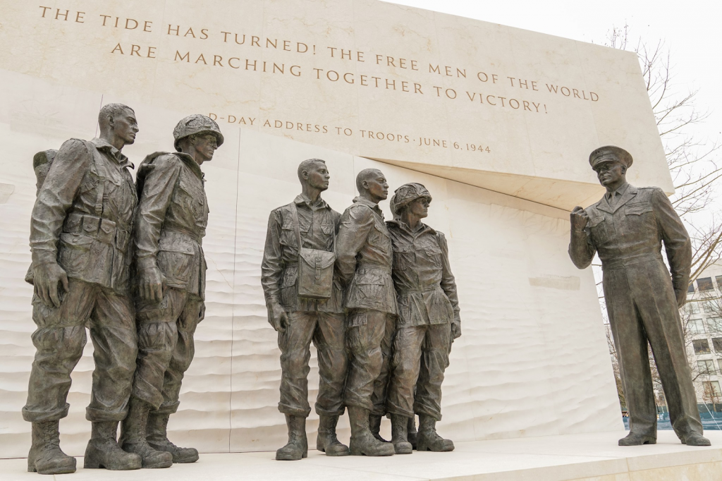 Photograph of the statues and sculptures at the Eisenhower Memorial. The statue depicts Eisenhower speaking to a group of soldiers giving the D-Day address to troops.