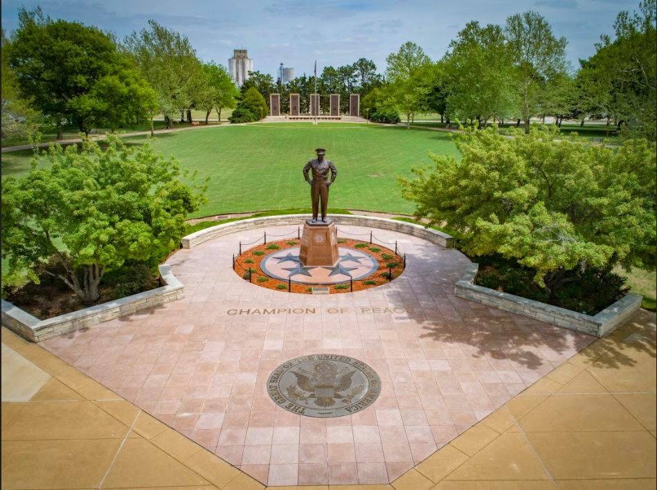 Photo of the Eisenhower Library Museum campus, showing a statue of Eisenhower in the middle of an emblem with the words "Champion of Peace."